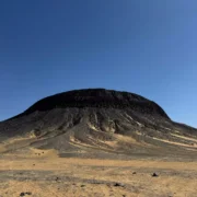 Black Desert volcanic hill near Bahariya Oasis Egypt under a clear blue sky