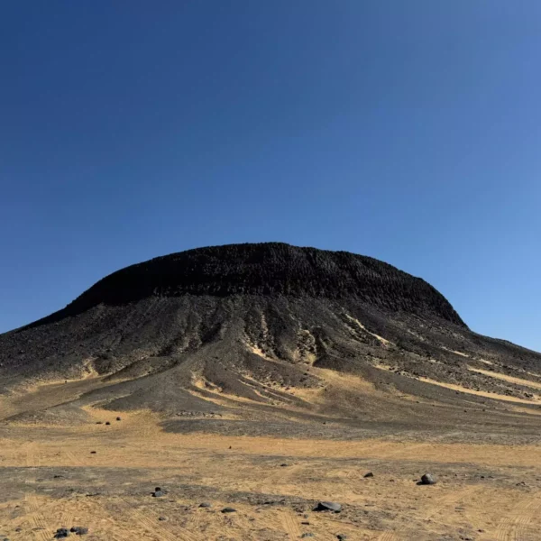 Black Desert volcanic hill near Bahariya Oasis Egypt under a clear blue sky