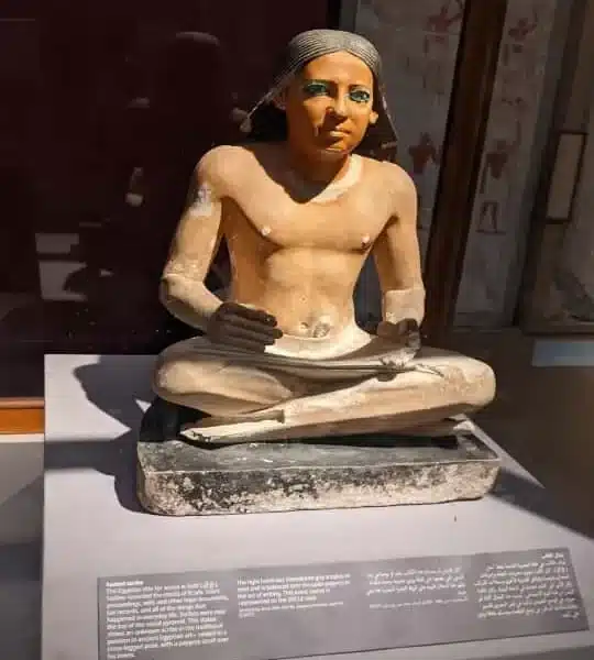 Ancient Egyptian seated statue displayed in a museum gallery