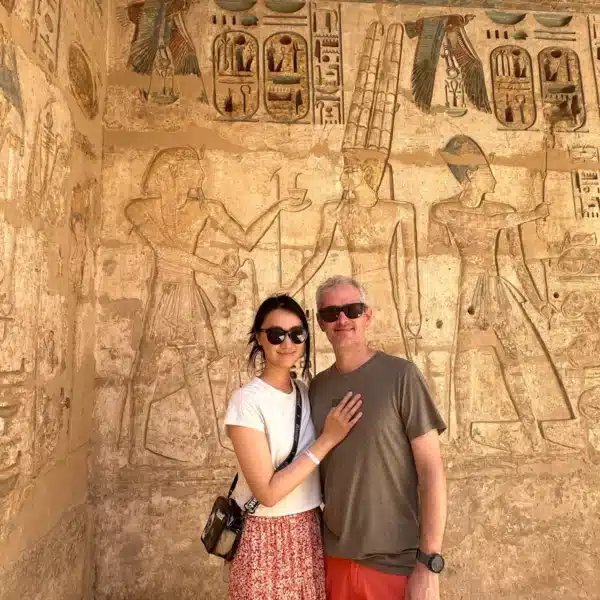 Couple visiting an ancient decorated tomb in Luxor