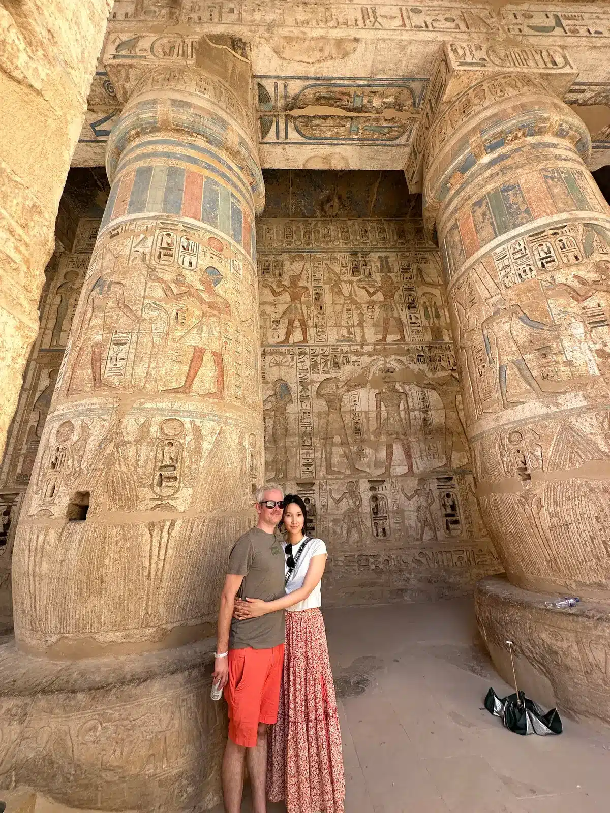 Travelers beside colorful decorated columns in a Luxor temple