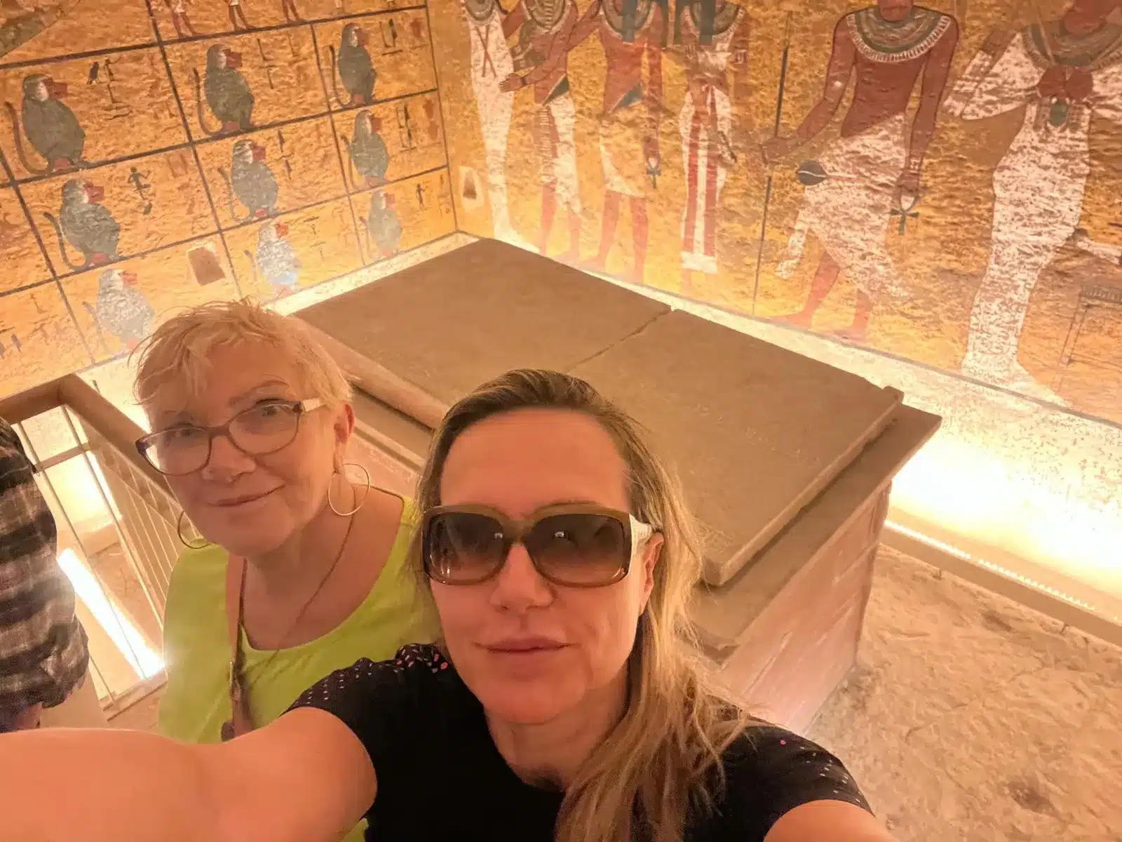 Travelers viewing colorful wall art inside a Valley of the Kings tomb