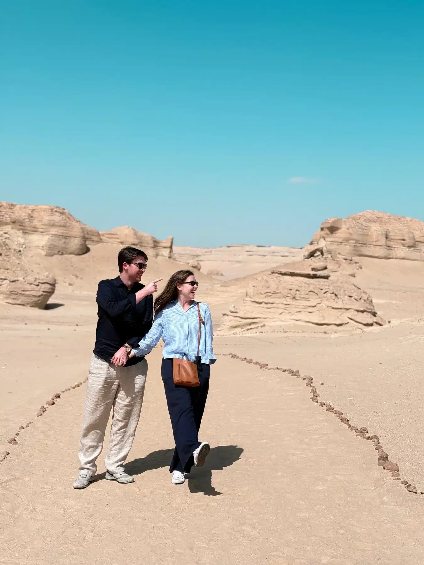 Couple exploring the desert landscape of Wadi Al Hitan Whale Valley