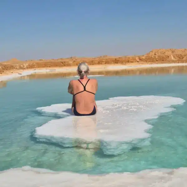 Traveler floating beside a salt formation in a Siwa salt lake