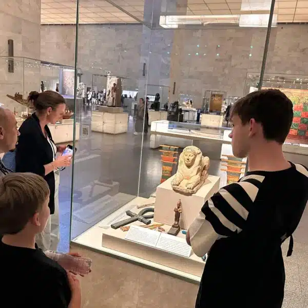 Visitors exploring an ancient Egyptian display inside the Grand Egyptian Museum