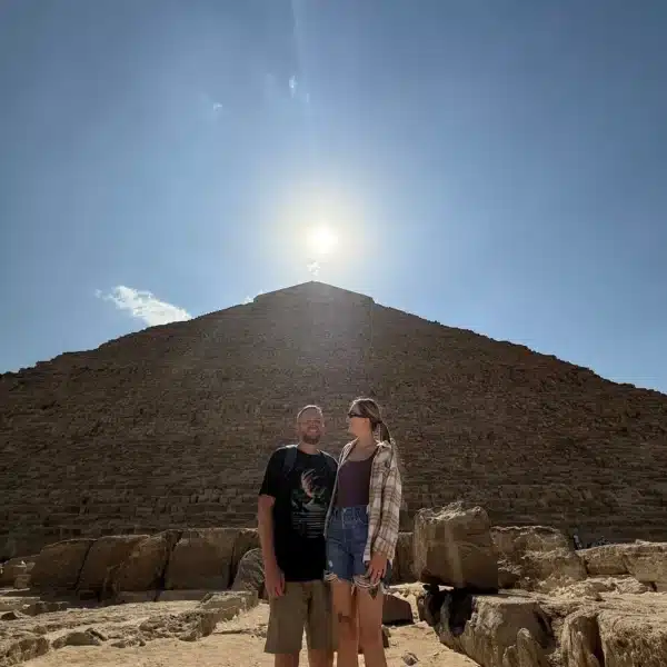 Travelers beneath the sun beside the Great Pyramid of Giza