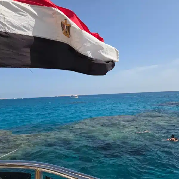 Egyptian flag above clear Red Sea water and coral reef near Hurghada