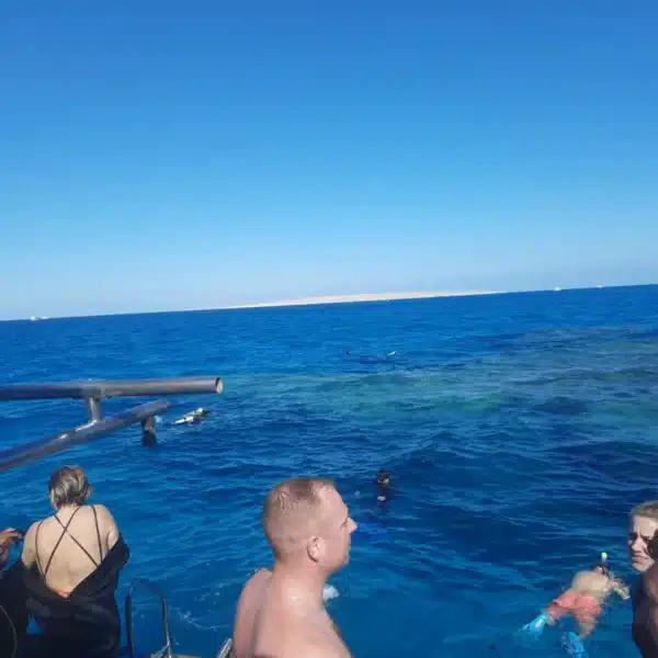 Travelers preparing to snorkel in clear Red Sea water near Hurghada