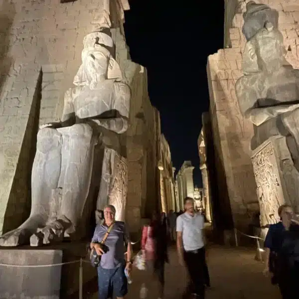 Illuminated statues and columns at Luxor Temple during an evening visit