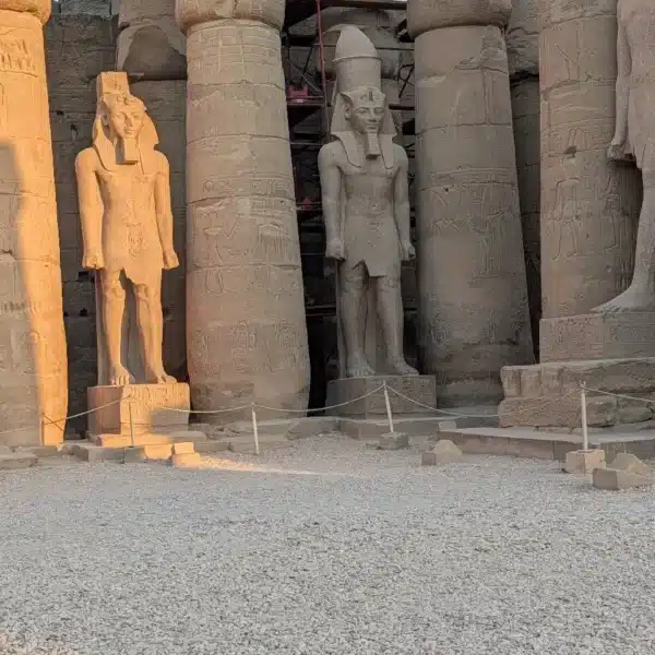 Ramses statues and columns at Luxor Temple in golden light