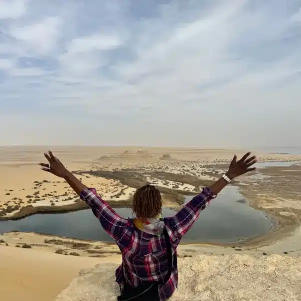 Traveler celebrating above Magic Lake in the Fayoum desert