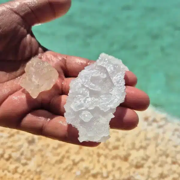 Natural translucent salt crystals beside turquoise water in Siwa