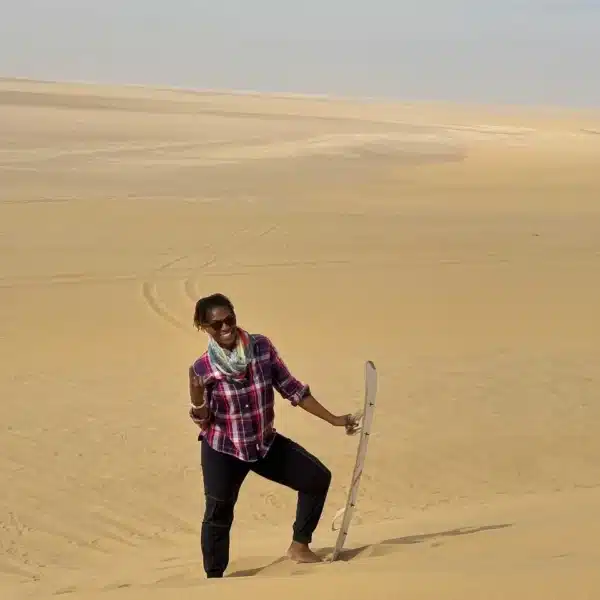 Traveler carrying a sandboard on the dunes of the Fayoum desert