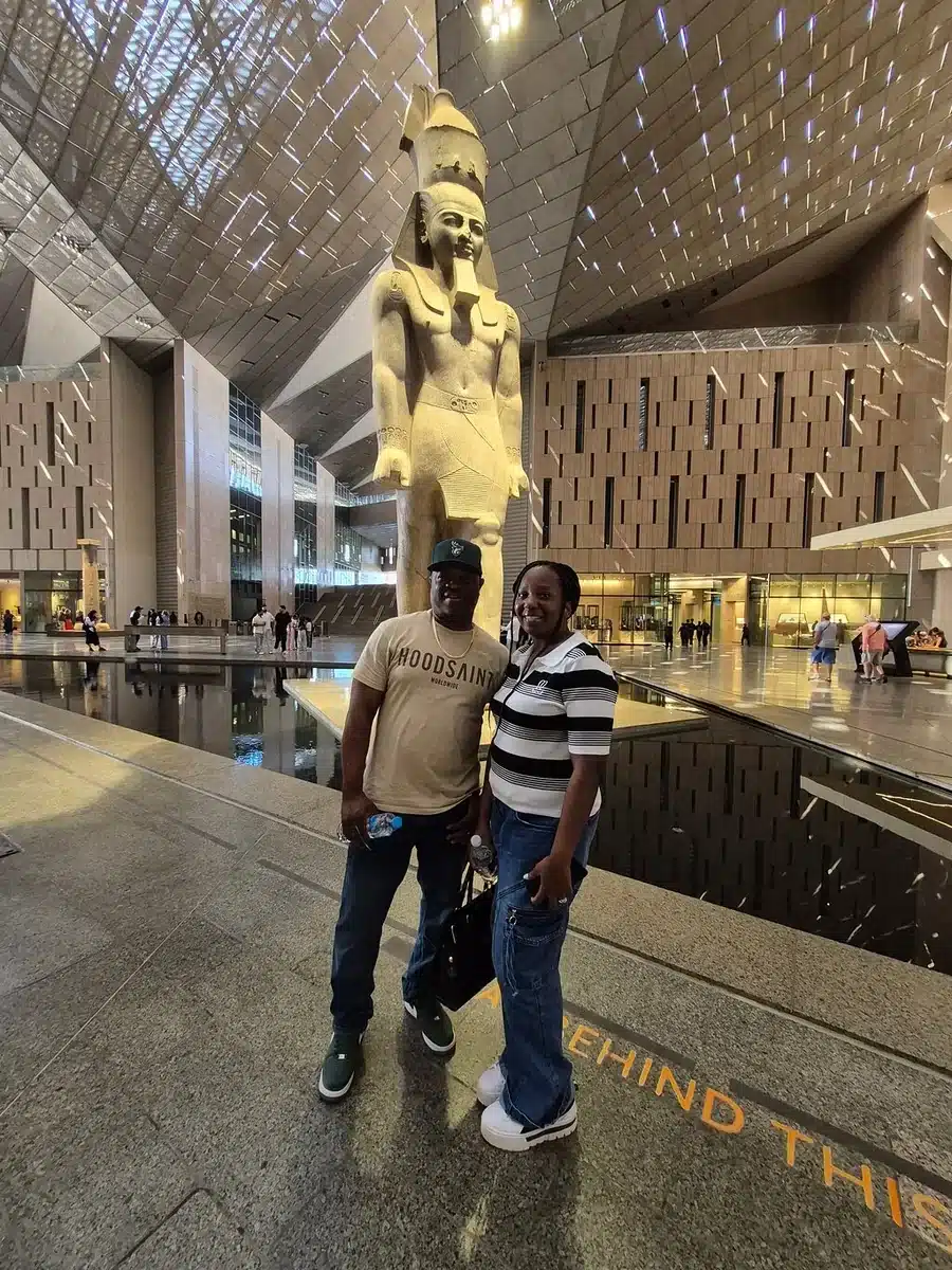 Visitors beside the Ramses II statue in the Grand Egyptian Museum Grand Hall